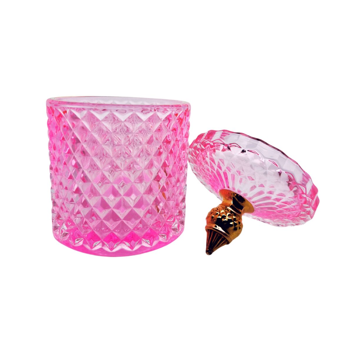 Pojemnik wraz z zakrętką do zalewu świec stojący na stole kolor różowy połysk zakrętką leżącą obok