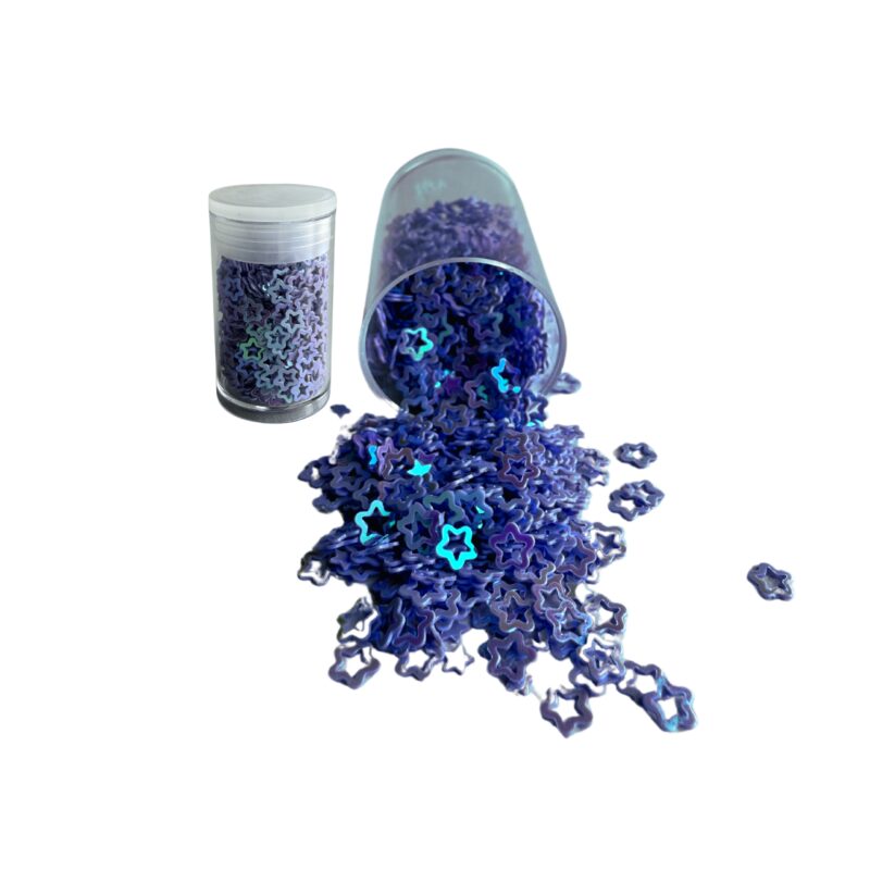 niebieskie gwiazdki do dekoracji, bardzo malutkie położone na białym stole