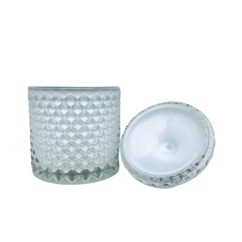 Pojemnik wraz z zakrętką do zalewu świec stojący na stole kolor biały połysk zakrętka przewrócona