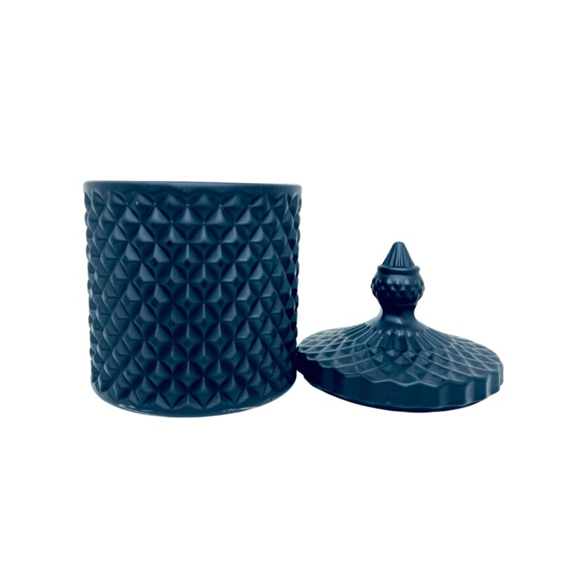 Pojemnik wraz z zakrętką do zalewu świec stojący na stole kolor czarny mat Żakrętka leżącą obok pojemnika