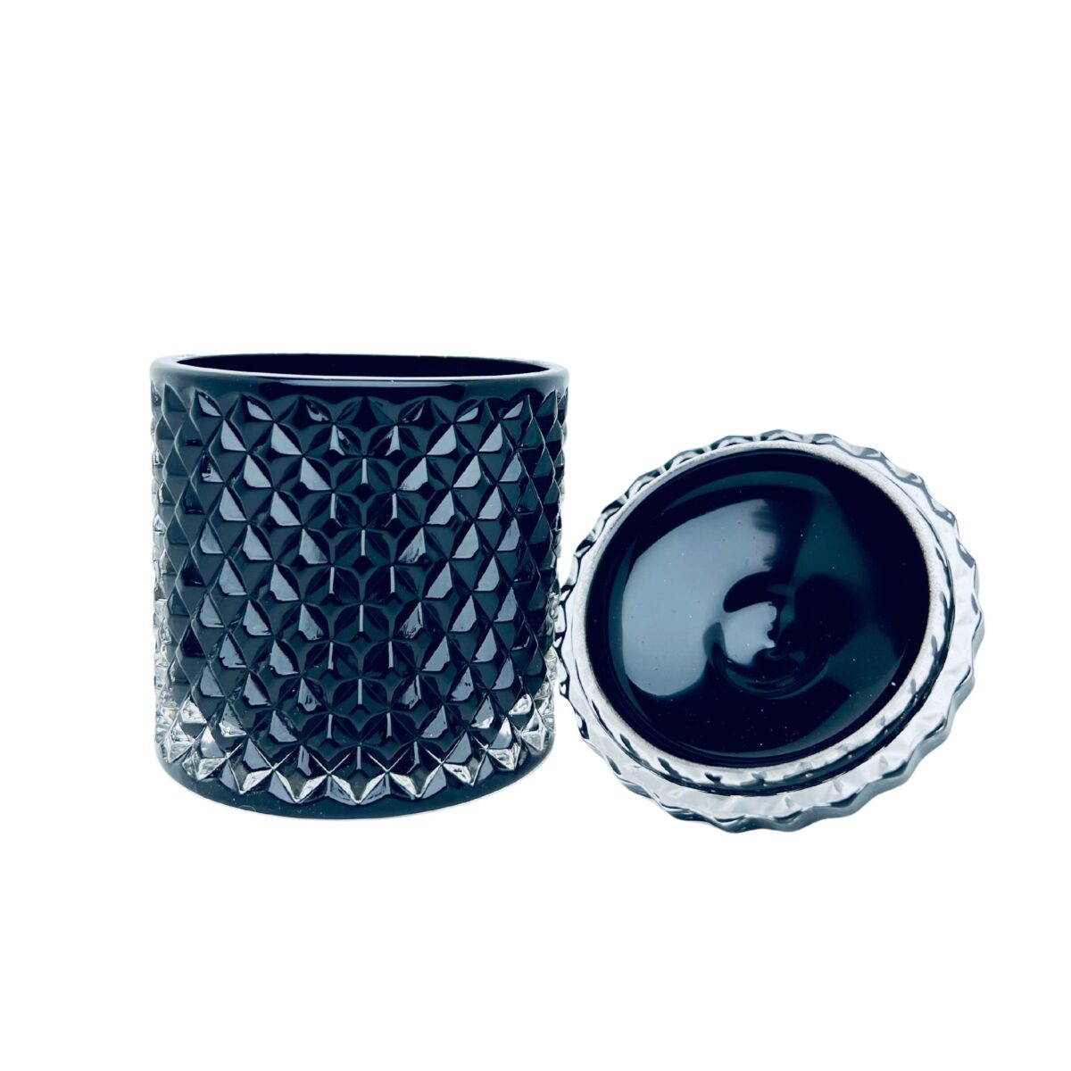 Pojemnik wraz z zakrętką do zalewu świec stojący na stole czarny połysk