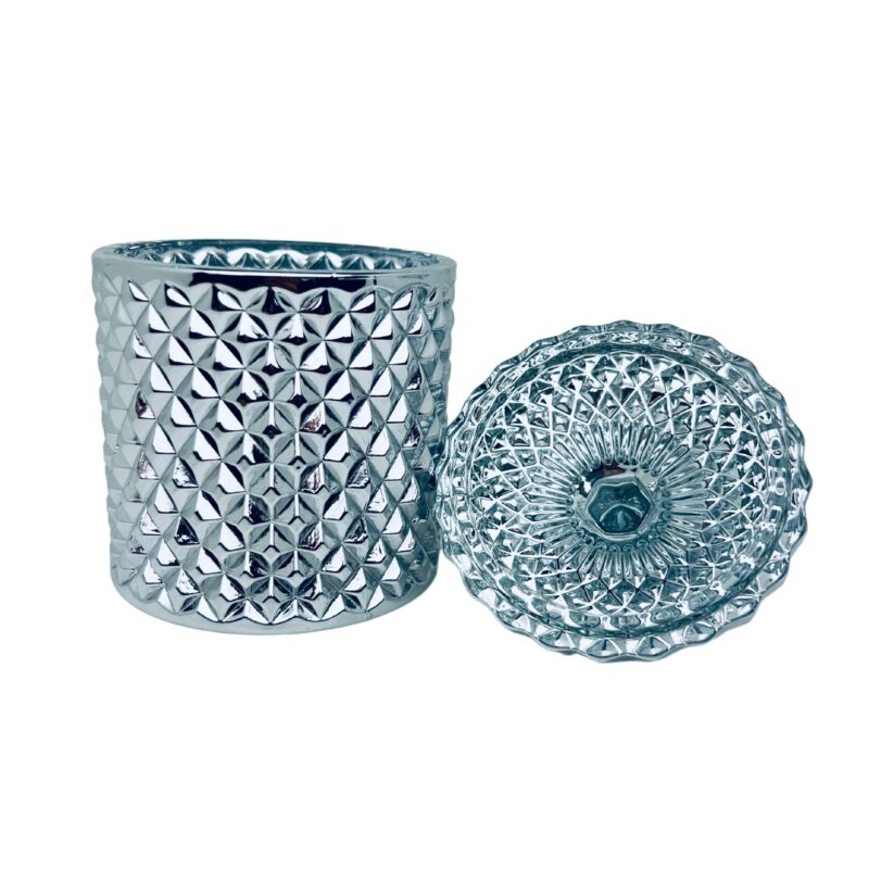 Pojemnik wraz z zakrętką do zalewu świec stojący na stole kolor srebrny połysk